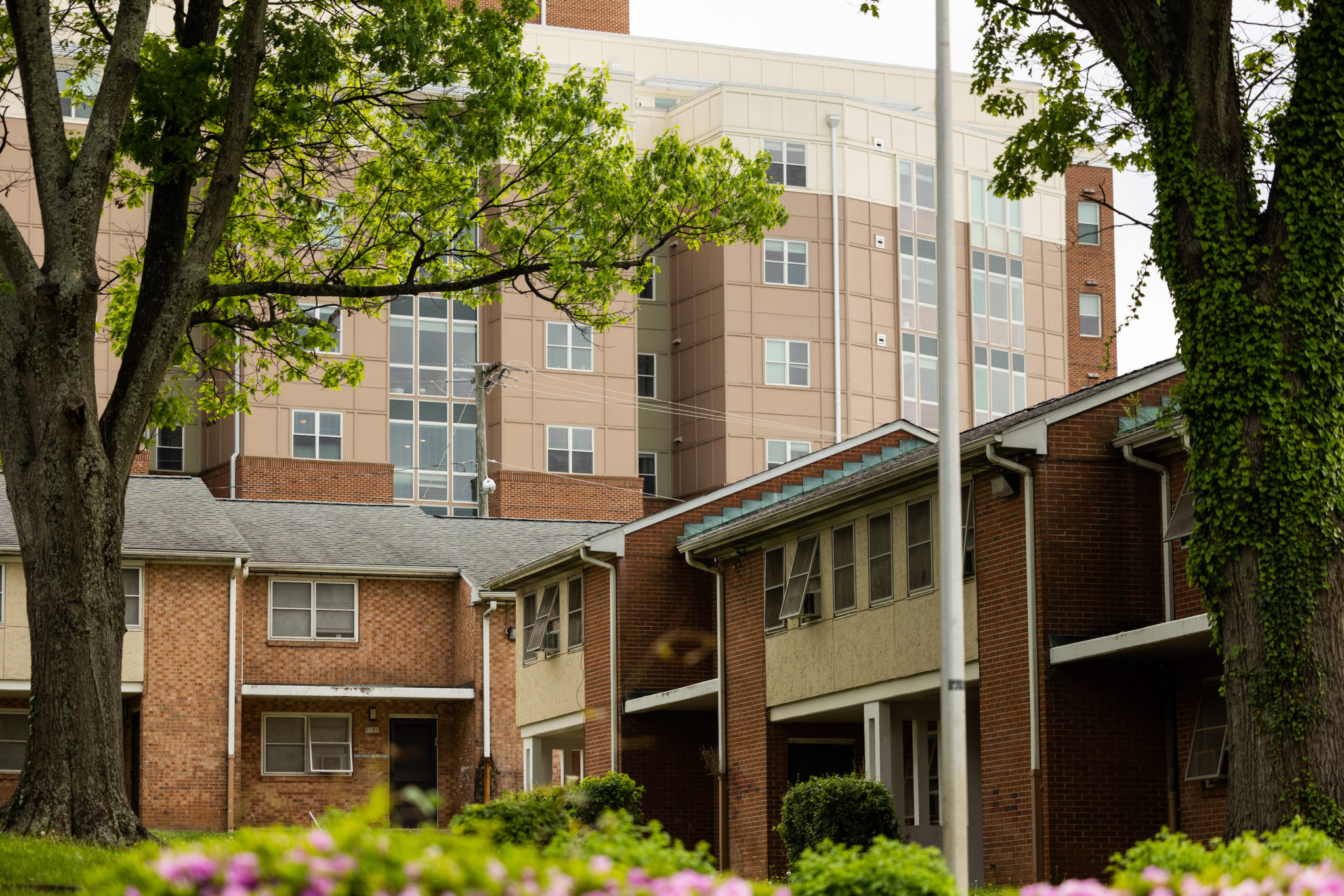 A tall apartment building stands behind a shorter apartment building.