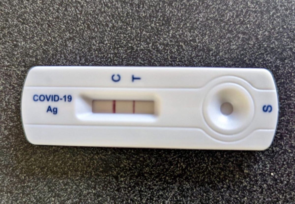 A COVID-19 test shows a positive result, with two pink lines next to the letters “C” and “T.”