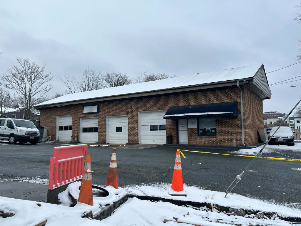 A brick building with a mostly empty parking lot covered in snow.