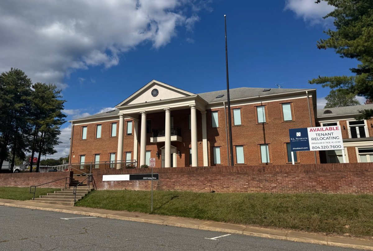 A large brick building with white columns is visible behind a low brick wall. A sign next to the building reads "Available, Tenant relocating."
