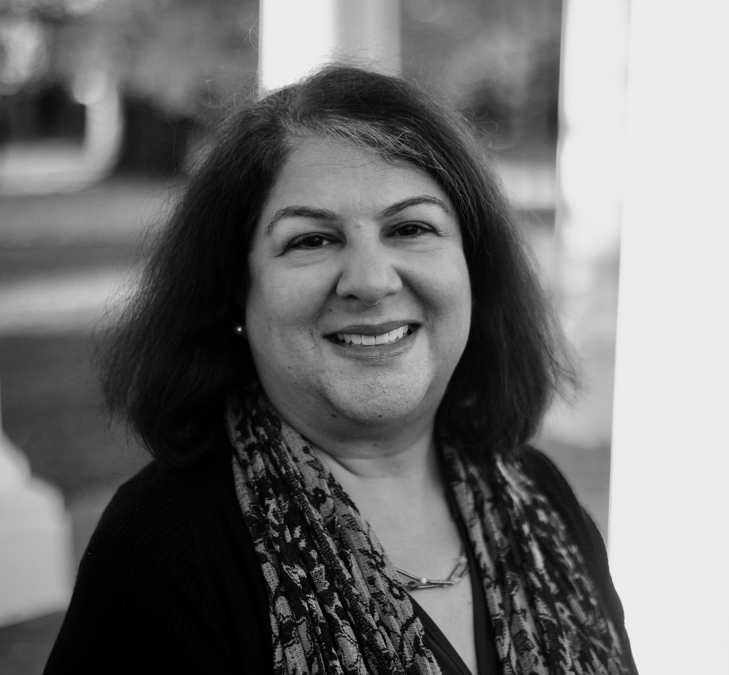 A black and white photo of a woman smiling for the camera